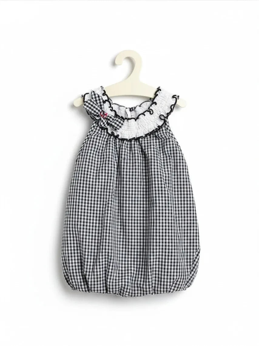 Elise Fay toddler bubble dress in black and white gingham check with a ruffled white collar and decorative bow.
